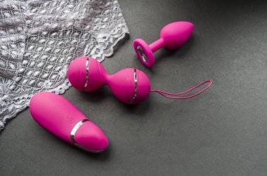 Uzaktan kumandalı yumurta ve pembe silikondan yapılmış anal fiş üzerinde titreşimli Ioni egzersiz makinesi. Siyah arkaplan fotoğrafında kadınların özel oyuncakları..