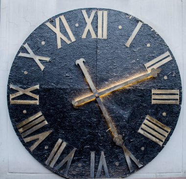 Pirinçten elleri ve Roma rakamlarıyla antik büyük siyah şehir saati. Kare fotoğraf.