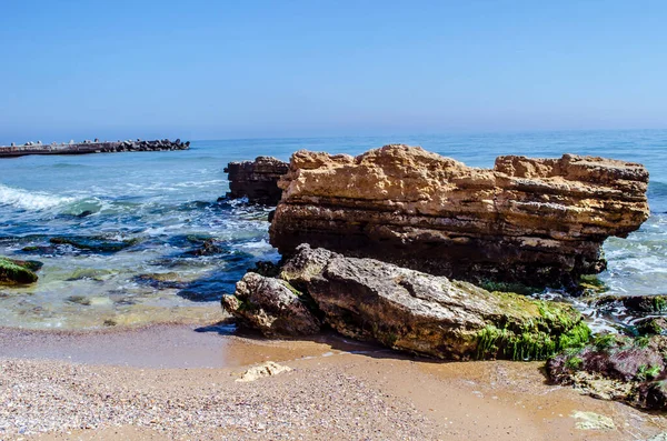 Kum sahili, kayalar ve deniz köpüğü. Doğal deniz manzarası fotoğrafı..
