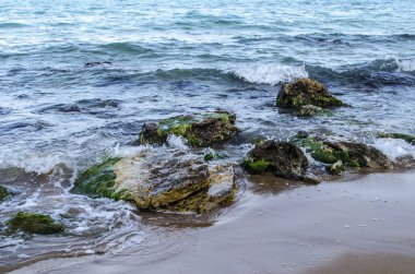Turkuaz sığ su yüzeyi ve deniz tabanında taşlar. Yüzeysel saydam deniz suyu dipte kayalar var.