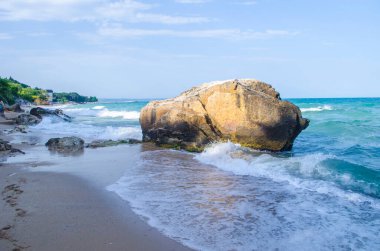 Turkuaz sığ su yüzeyi ve deniz tabanında taşlar. Yüzeysel saydam deniz suyu dipte kayalar var.