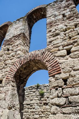 A stone arched window in the ruins of an ancient Mediterranean city. Architectural vintage detail photo.