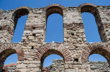 A stone arched window in the ruins of an ancient Mediterranean city. Architectural vintage detail photo.