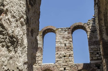 A stone arched window in the ruins of an ancient Mediterranean city. Architectural vintage detail photo.