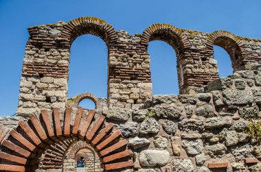 A stone arched window in the ruins of an ancient Mediterranean city. Architectural vintage detail photo.