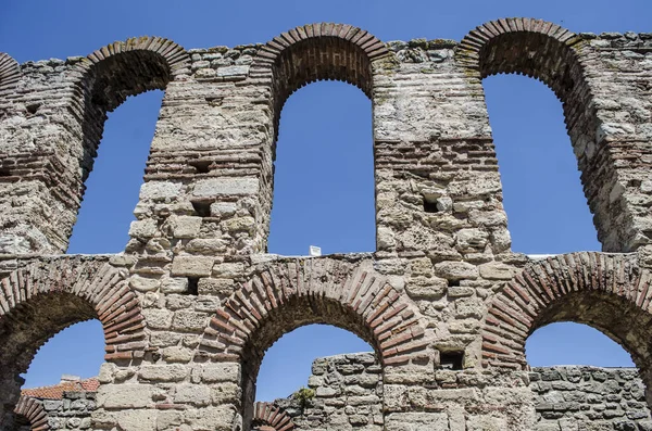 A stone arched window in the ruins of an ancient Mediterranean city. Architectural vintage detail photo.