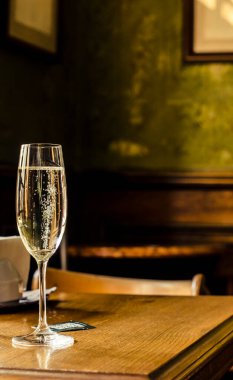 Eski bir evin arka planında köpüklü bir bardakta köpüklü şarap. Alkollü içki fotoğrafı..