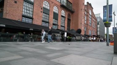 Oslo, Norveç. Eylül 2021. Stranden caddesinde, şehir merkezindeki marinanın önünde gezinen insanların hızlandırılmış görüntüsü..