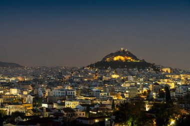 Atina, Yunanistan. Kasım 2021. Gün batımında şehrin ve Lycabettus Tepesinin havadan görüntüsü.
