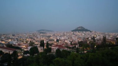 Atina, Yunanistan. Kasım 2021. Günbatımında Akropolis 'ten şehrin ve Lycabettus tepesinin panoramik hızlandırılmış görüntüsü