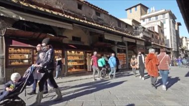 Floransa, İtalya. Ocak 2022 'de şehir merkezindeki Arnon Nehri üzerinden Ponte Vecchio' daki dükkanlar arasında dolaşan turistlerin görüntüsü