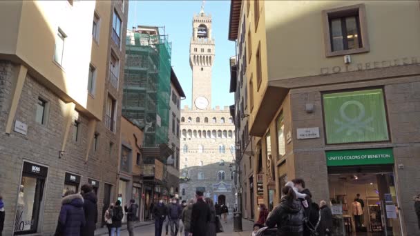 イタリアのフィレンツェ 2022年1月 背景にパラッツォ ヴェッキオの景色を望む市内中心部の通りを歩く観光客 — ストック動画