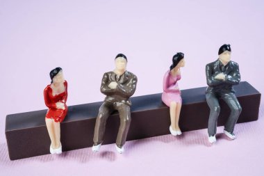 Renkli bir yüzeyde bazı minyatür insanlar birbiriyle ilişkilidir.