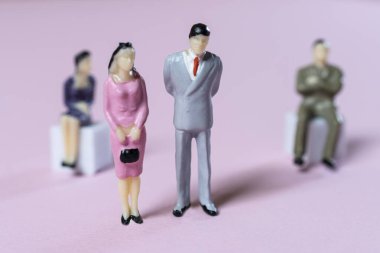 Renkli bir yüzeyde bazı minyatür insanlar birbiriyle ilişkilidir.