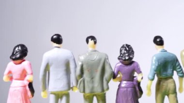 Beyaz arka planda bir sıra minyatür insanın kaydırılması.