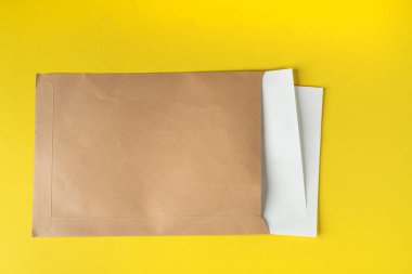 Bir kaç beyaz kağıt içeren kahverengi bir zarf.