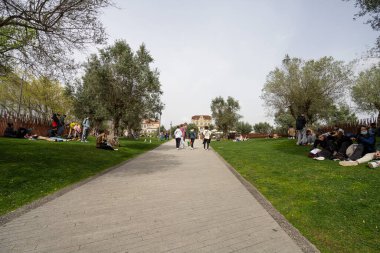Porto, Portekiz. Mart 2022 'de Lizbon Meydanı' ndaki parkın çimlerinde dinlenen insanlar görülüyor.