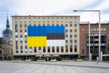 Tallinn, Estonya. Temmuz 2022, Estonya ve Ukrayna bayrakları şehir merkezindeki bir binanın ön cephesinde görülüyor.
