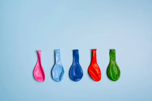 some colorful deflated balloons arranged in a row