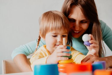 Anne ve kızının piramit inşaatçısı oyuncağıyla oynadığı portreyi kapat