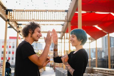 Genç hippi erkek ve kız beşlik çakıyor. Mutlu duygusal portre.