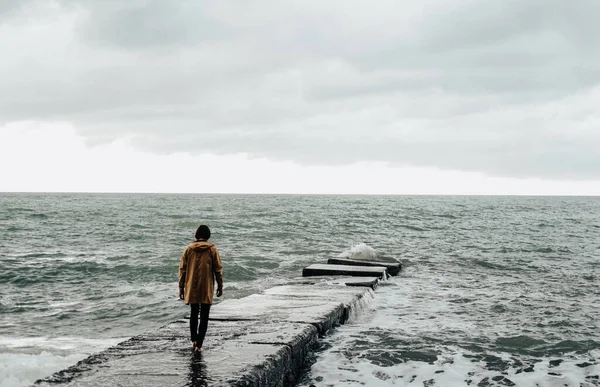 Pria Kesepian Dengan Jas Hujan Kuning Berjalan Sepanjang Pemecahan Air Stok Gambar