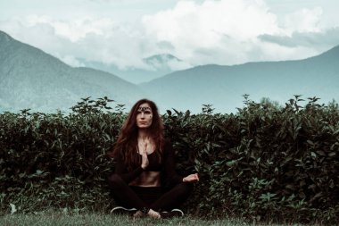 Yeşilliğin arka planında güzel bir genç kadın. Boho tarzı. Orman perisi..