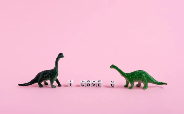 かわいい緑の恐竜と私はピンクの背景にあなたを愛して碑文 聖バレンタインデーカード — ストック写真