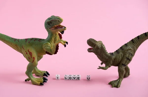 Cute dinosaurs and the inscription I love you on a pink background. Saint Valentine's day card.