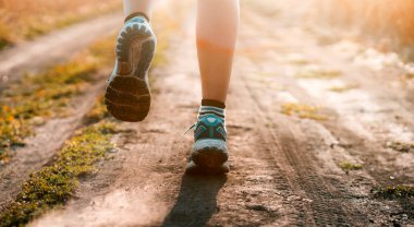 Genç kız gün batımında koşuyor..