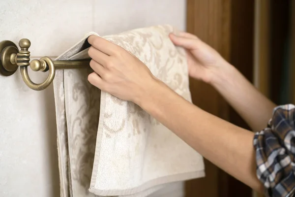 Girl is hanging clean towel on a holder. — Stock Photo, Image