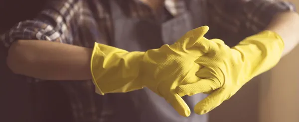A woman in yellow rubber gloves does housework — Stock Photo, Image