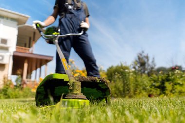 Bahçıvan güneşli bir günde çim biçiyor..