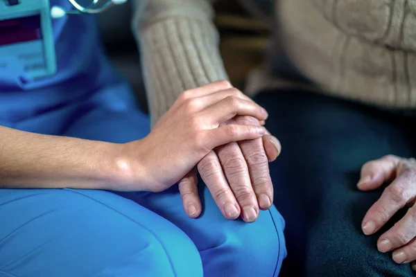 年轻女人的手牵着奶奶的手，一个老年病人. — 图库照片