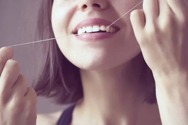 Девушка чистит зубы зубной нитью утром. — стоковое фото