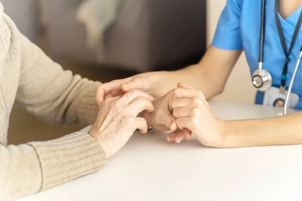 A young nurse shows care and professionalism in relation to an elderly woman — Stock Photo, Image