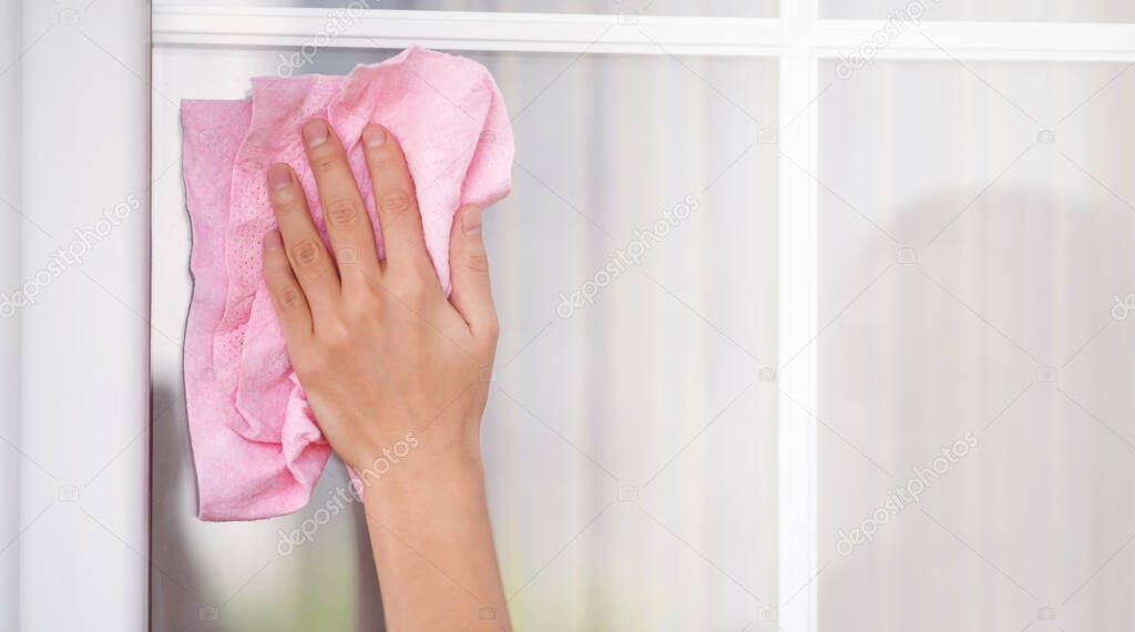 Female hand washes the window with a rag.