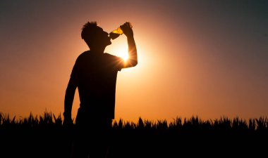 Günbatımında insan silueti, insan su içer..