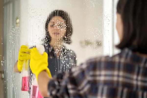 若い女性が浴室で鏡を洗っている. — ストック写真