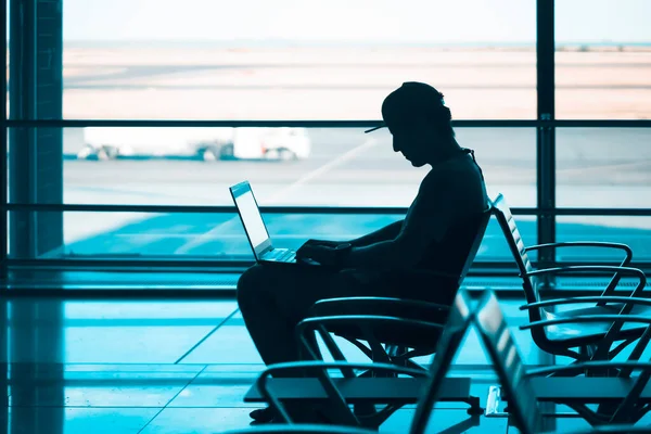 L'uomo lavora su un portatile all'aeroporto. — Foto Stock