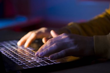 Eller dizüstü bilgisayarın klavyesinde.