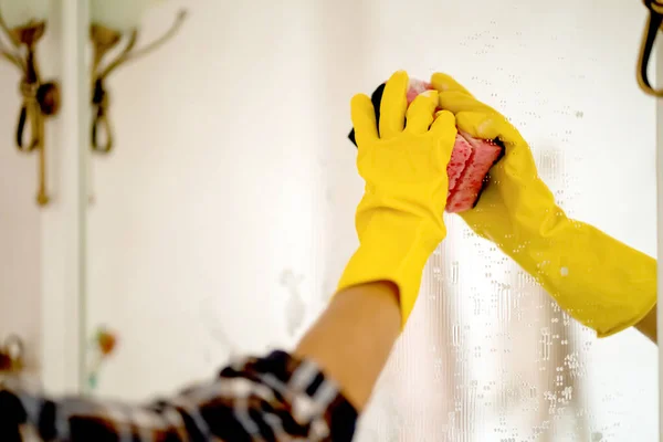 Młoda kobieta myje lustro w szlafroku. — Zdjęcie stockowe