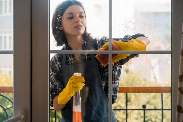 女性は洗剤で窓を洗う. — ストック写真