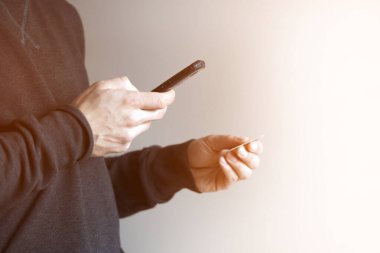 Man holds bank card and mobile phone in his hands.