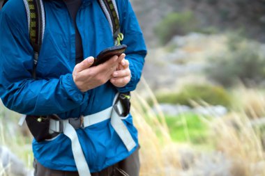 Adam doğa yürüyüşü yapıyor, açık havada telefonla yürüyor..