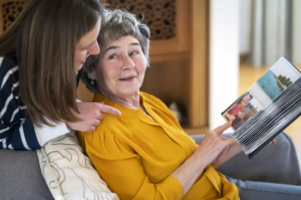Стара жінка з онукою дивиться на сімейні фотографії . Стокове Зображення