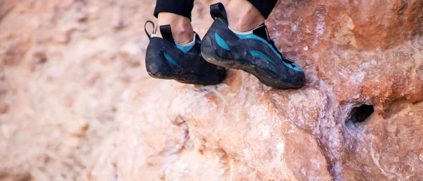 Nohy s lezeckými botami na skalách detailní záběr. — Stock fotografie