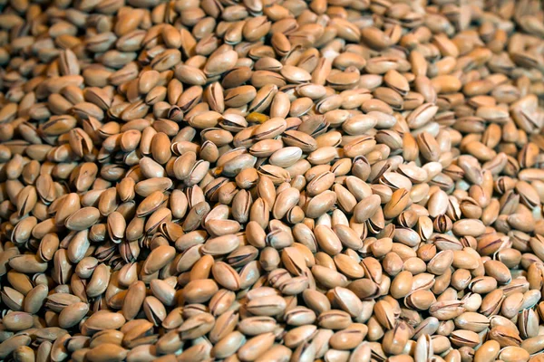 Lots of pistachios, background with tasty nuts.