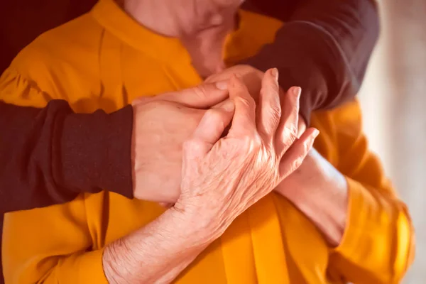 Young Man Volunteer Son Carefully Hugs His Beloved Grandmother Supports — Fotografia de Stock