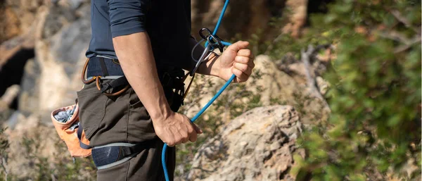 若い男は 屋外の山の中でロッククライミングのために嘘をつく アスリートは ワークアウト中にロープを制御 晴れた日に登山に行きます クローズアップ — ストック写真